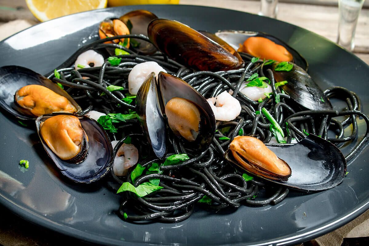 Traditional Venetian squid ink spaghetti served with fresh mussels and shrimp.