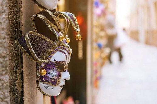 Purple Venetian jester mask in a street