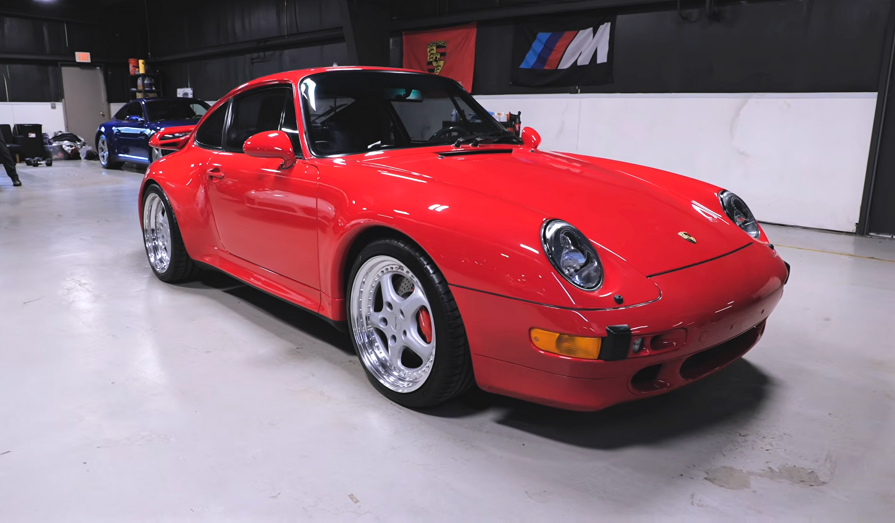 Black sports car in an indoor showroom with a large red 