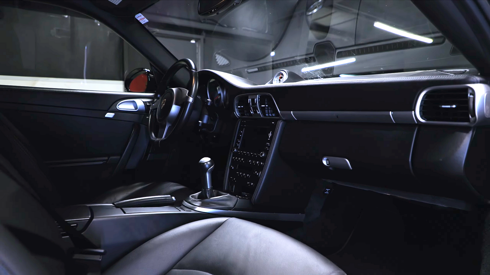 Interior of a modern car with black seats, dashboard, and center console viewed from the passenger side