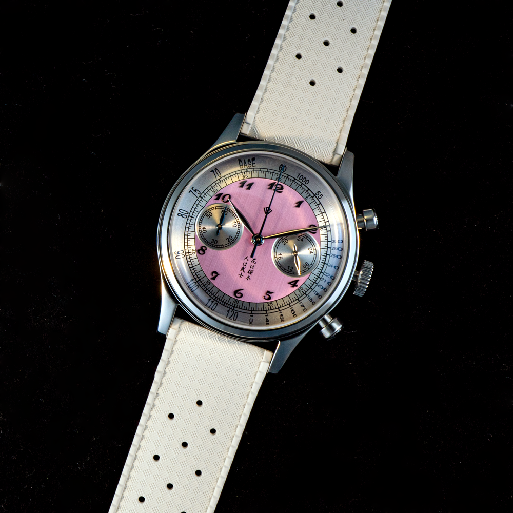A watch with a pink face and a white band