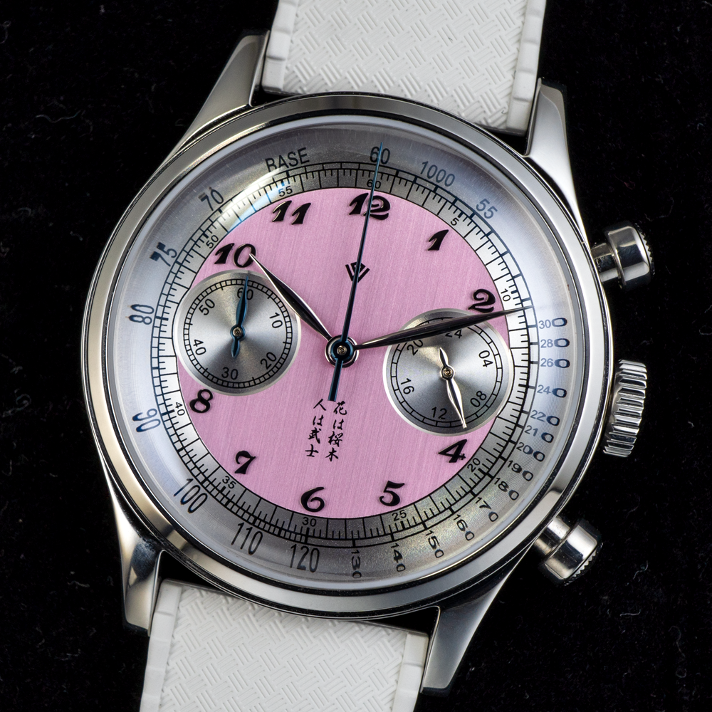 A silver watch with a pink face and white band