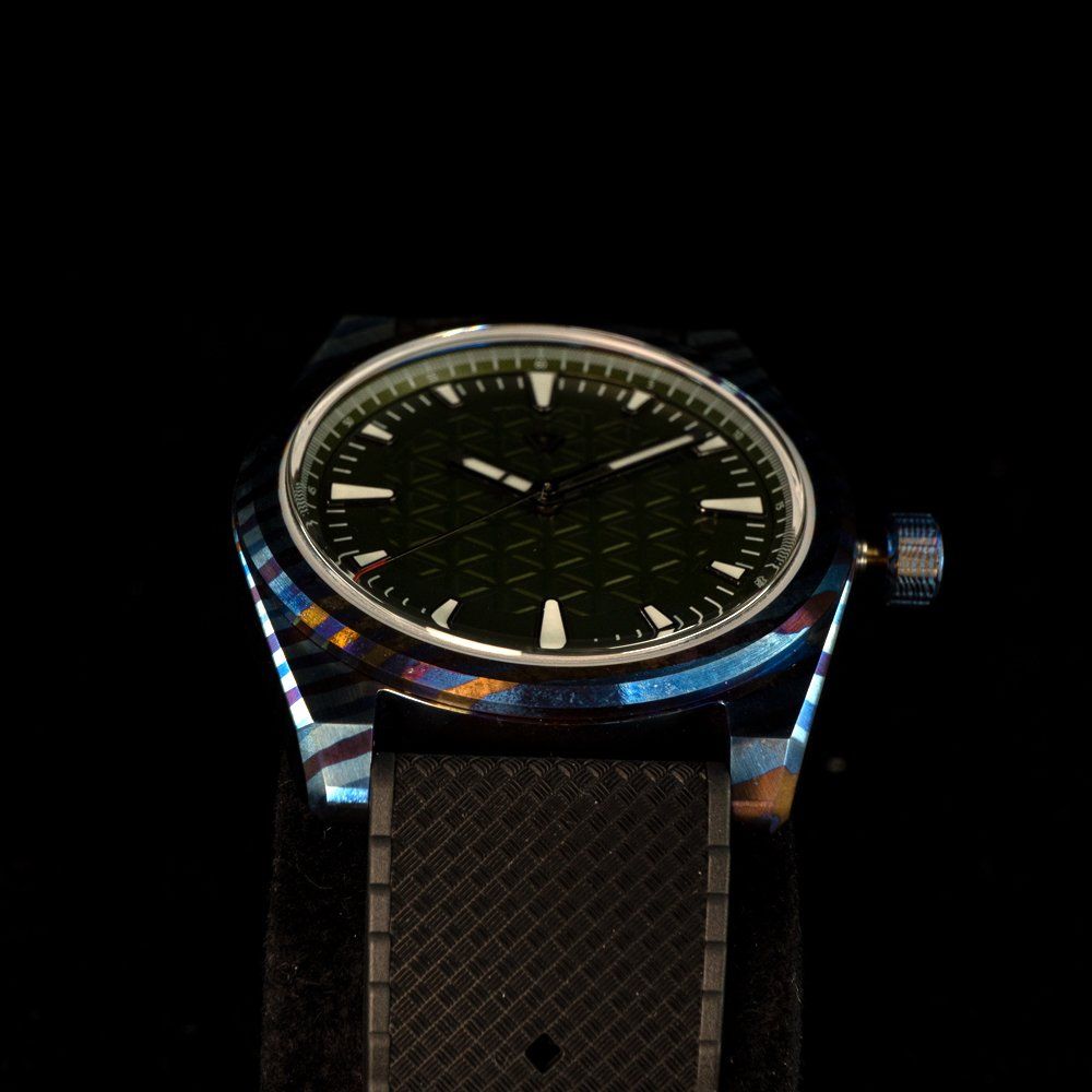 A watch with a black band and a green face