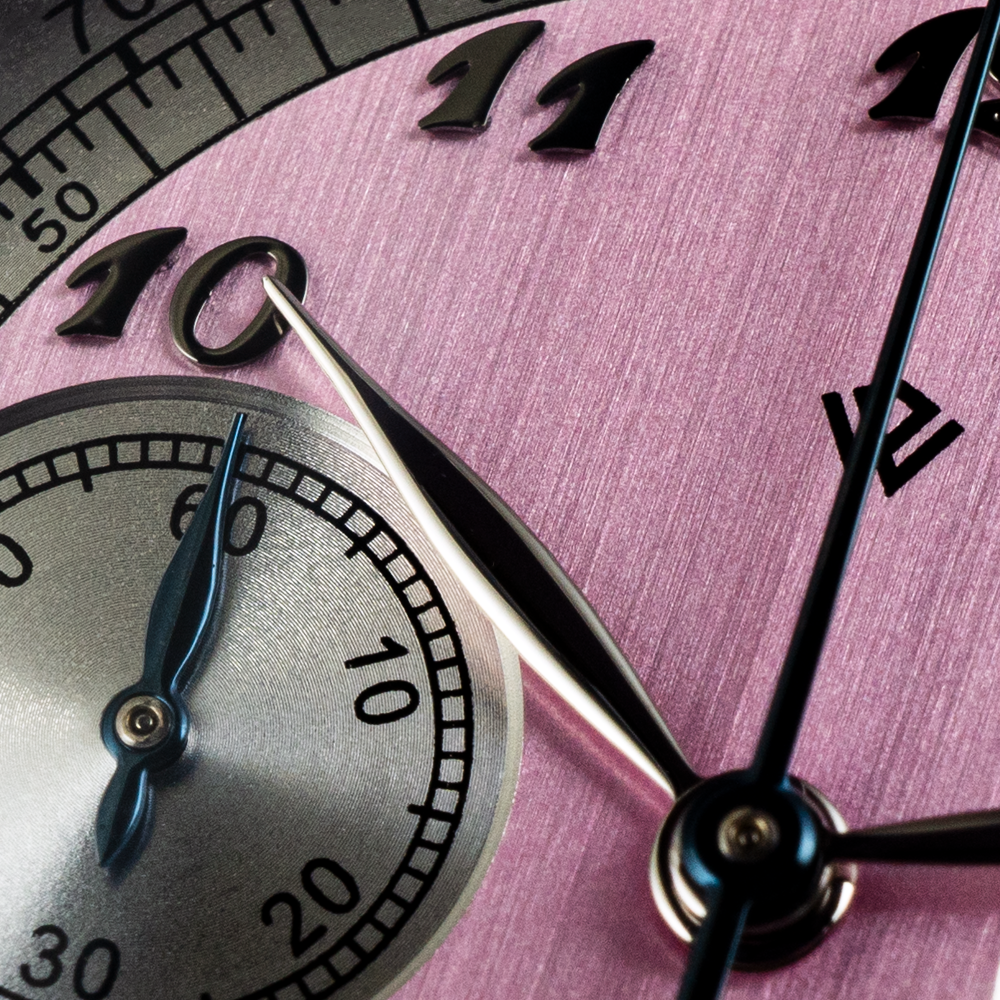 A close up of a pink clock with the hands on the numbers 10 and 11