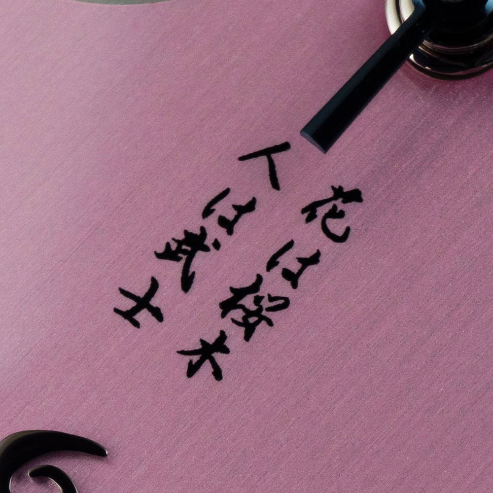 A close up of a clock face with chinese writing on it