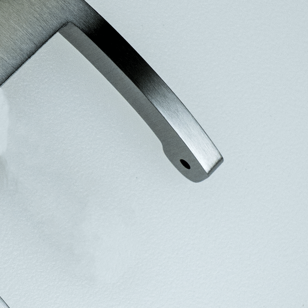 A close up of a metal object on a white surface