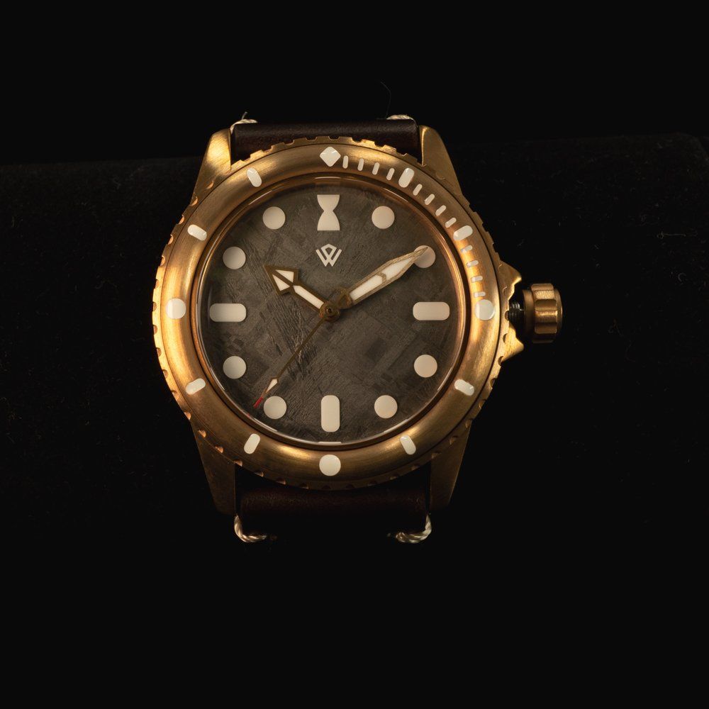 A gold watch with a black face and white numbers