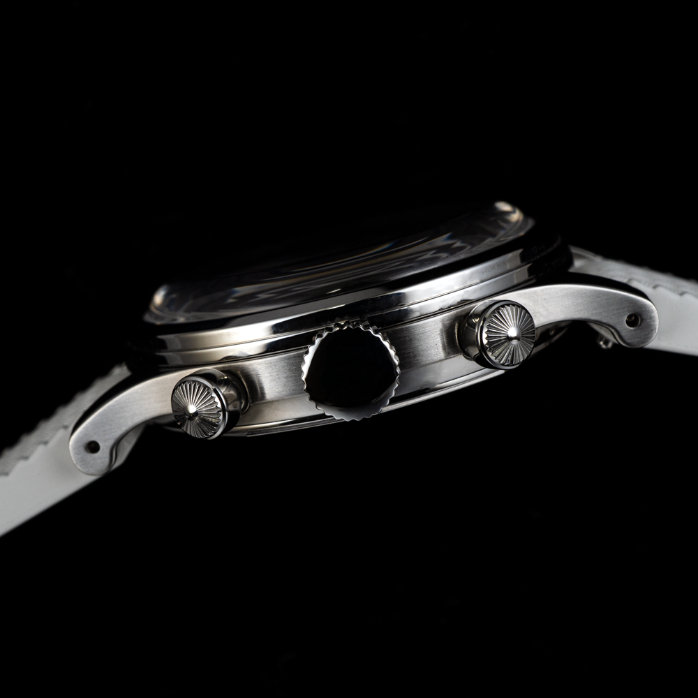 A close up of the side of a watch on a black background.