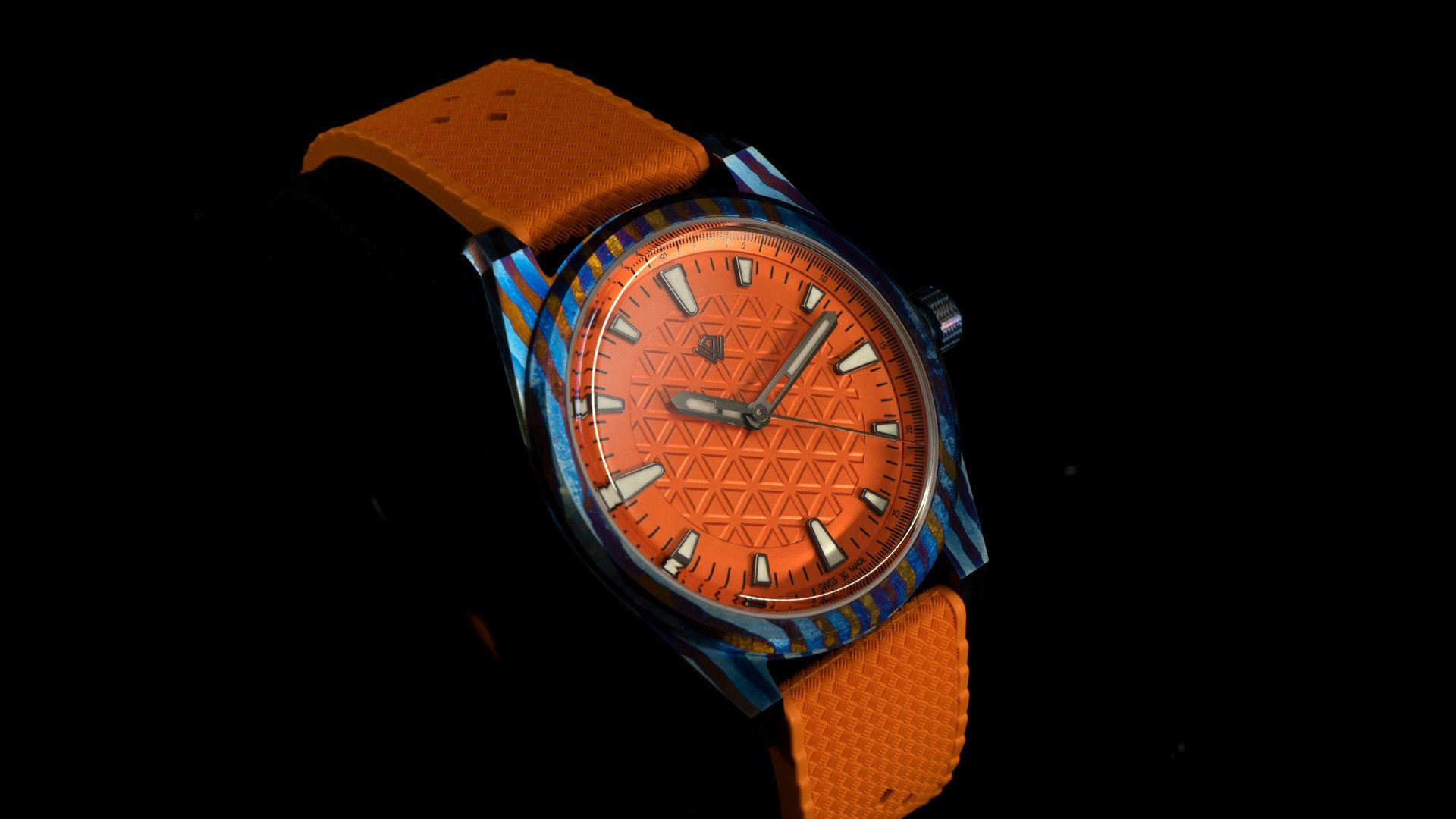 A close up of a watch with an orange band on a black background.