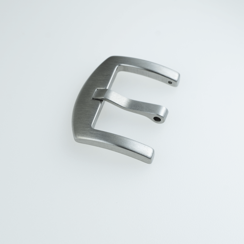 A silver letter e is on a white surface