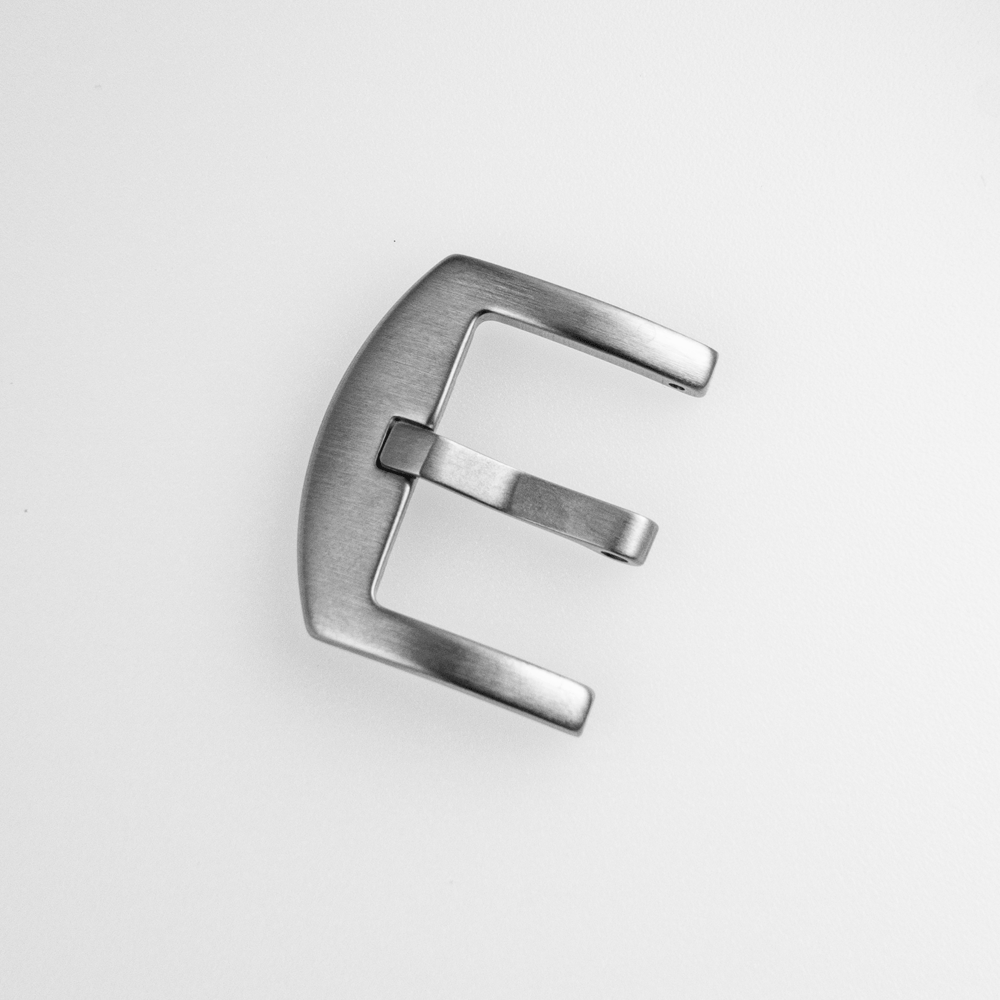 A silver buckle with the letter e on it
