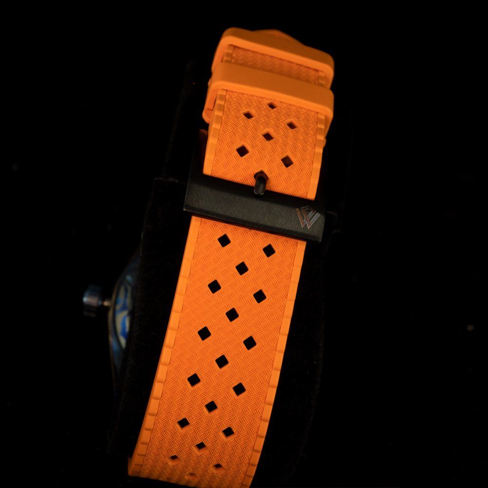 A close up of an orange watch band on a black background