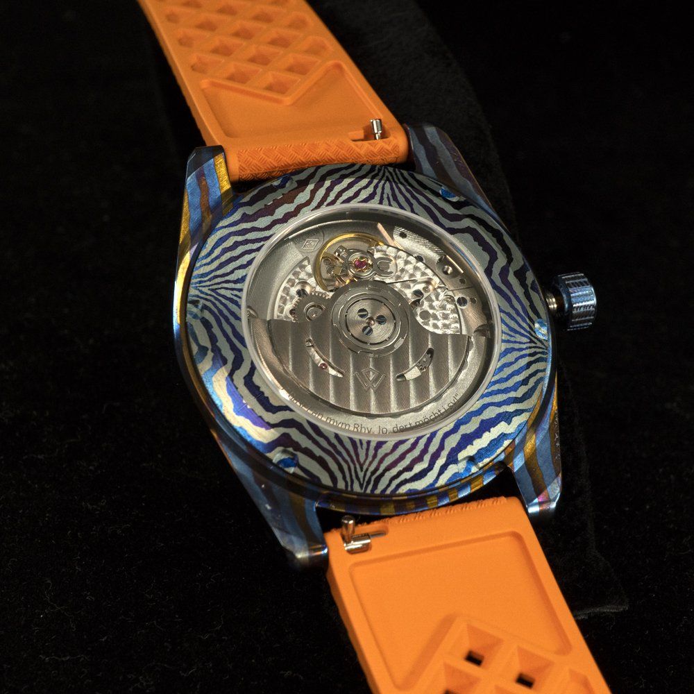 The back of a watch with an orange band