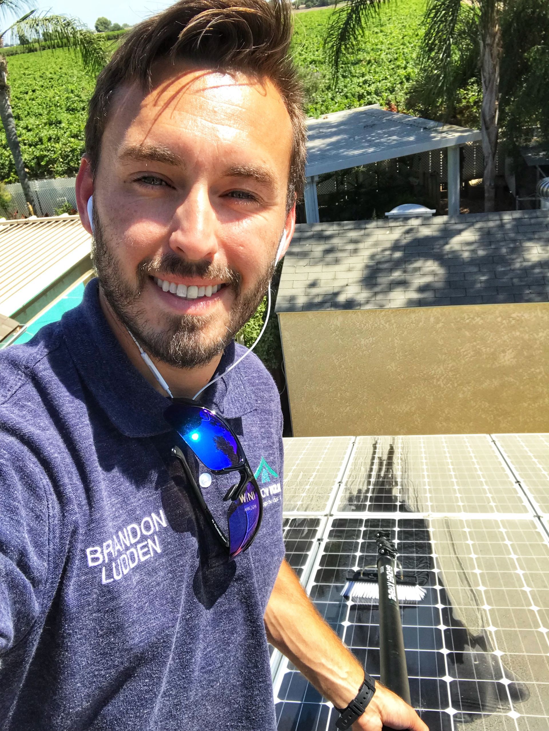 A man is taking a selfie with a solar panel in the background.