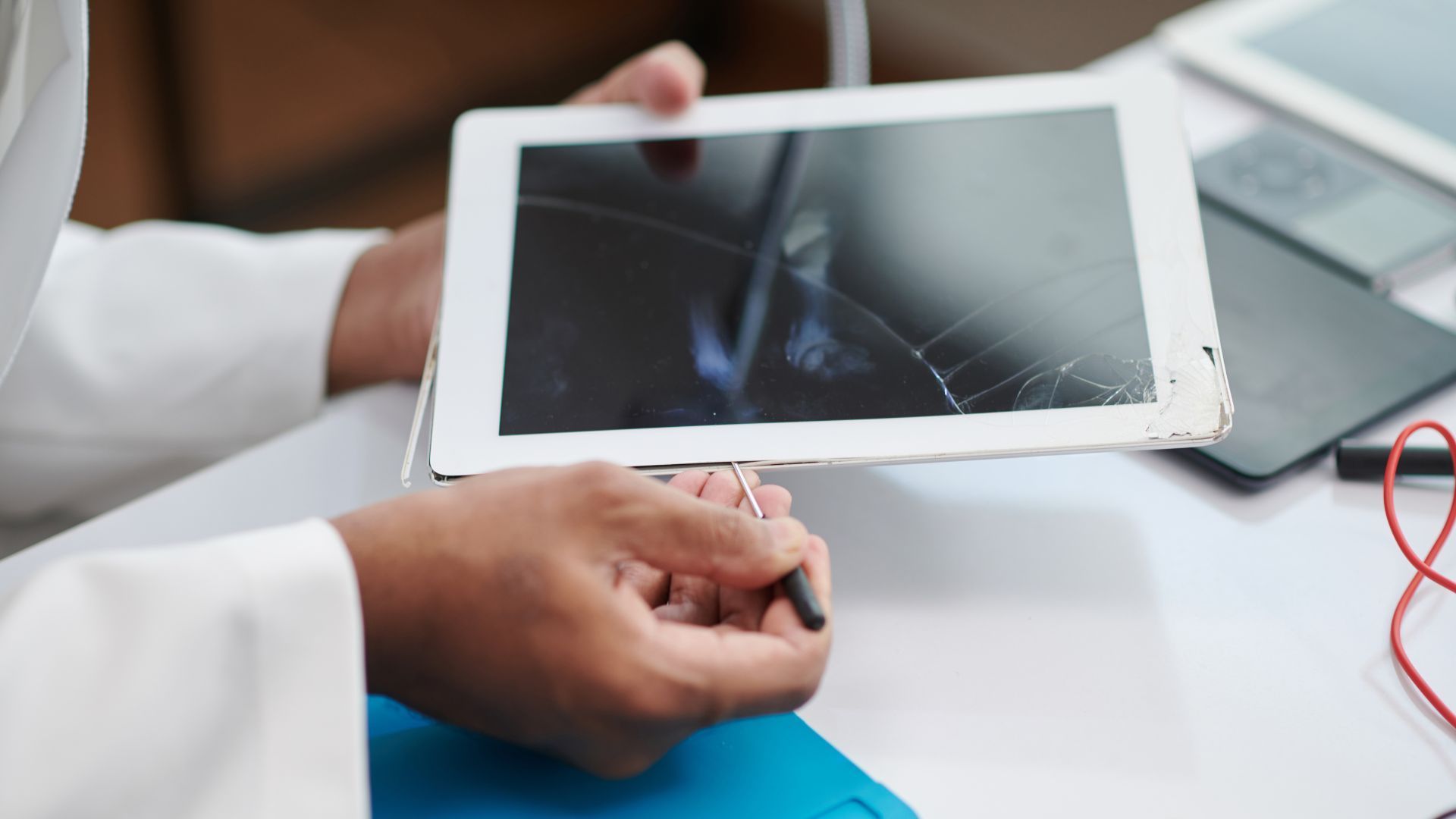 A person is holding a tablet with a broken screen.