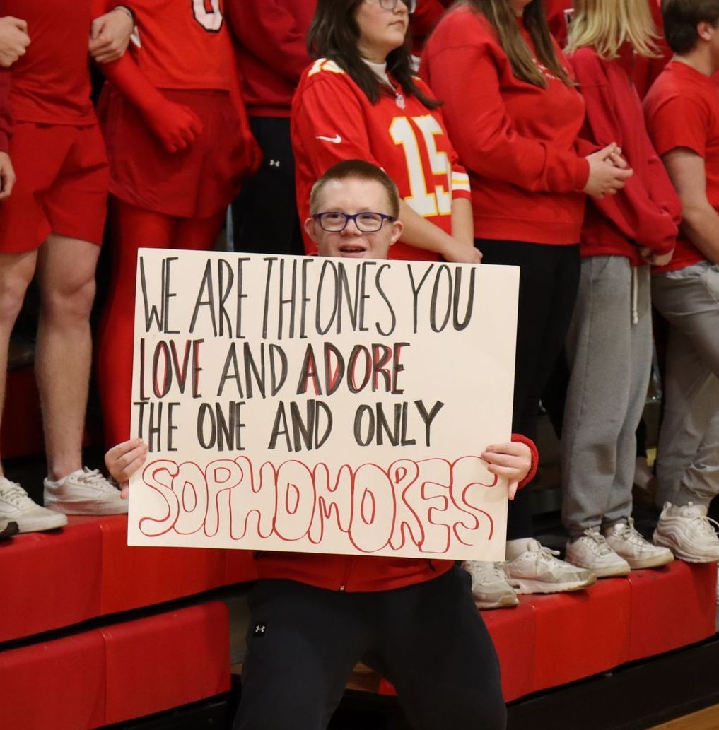 Person holding a sign reading 