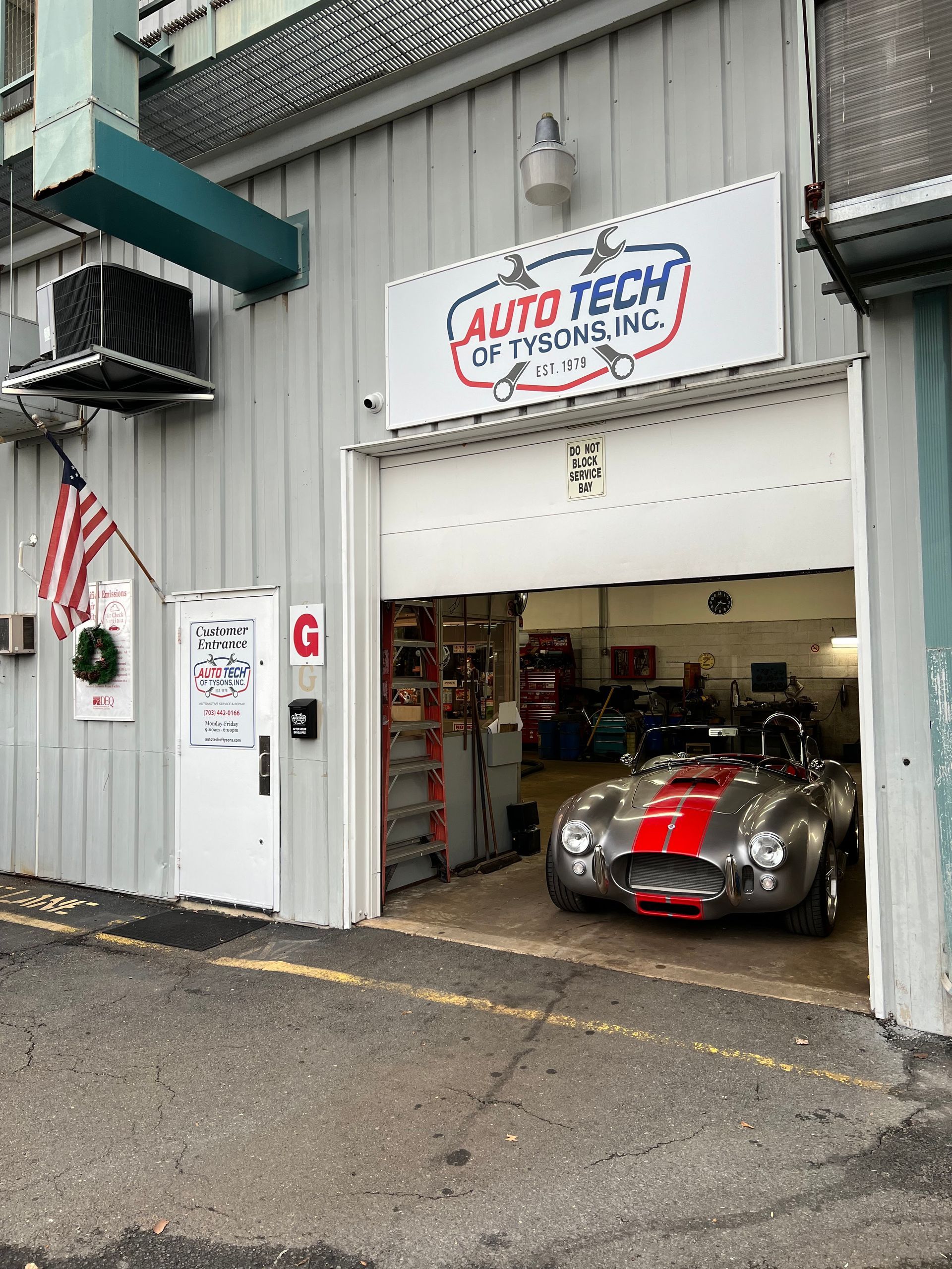 Auto repair shop entrance with a classic silver car and red stripe | Auto Tech of Tysons