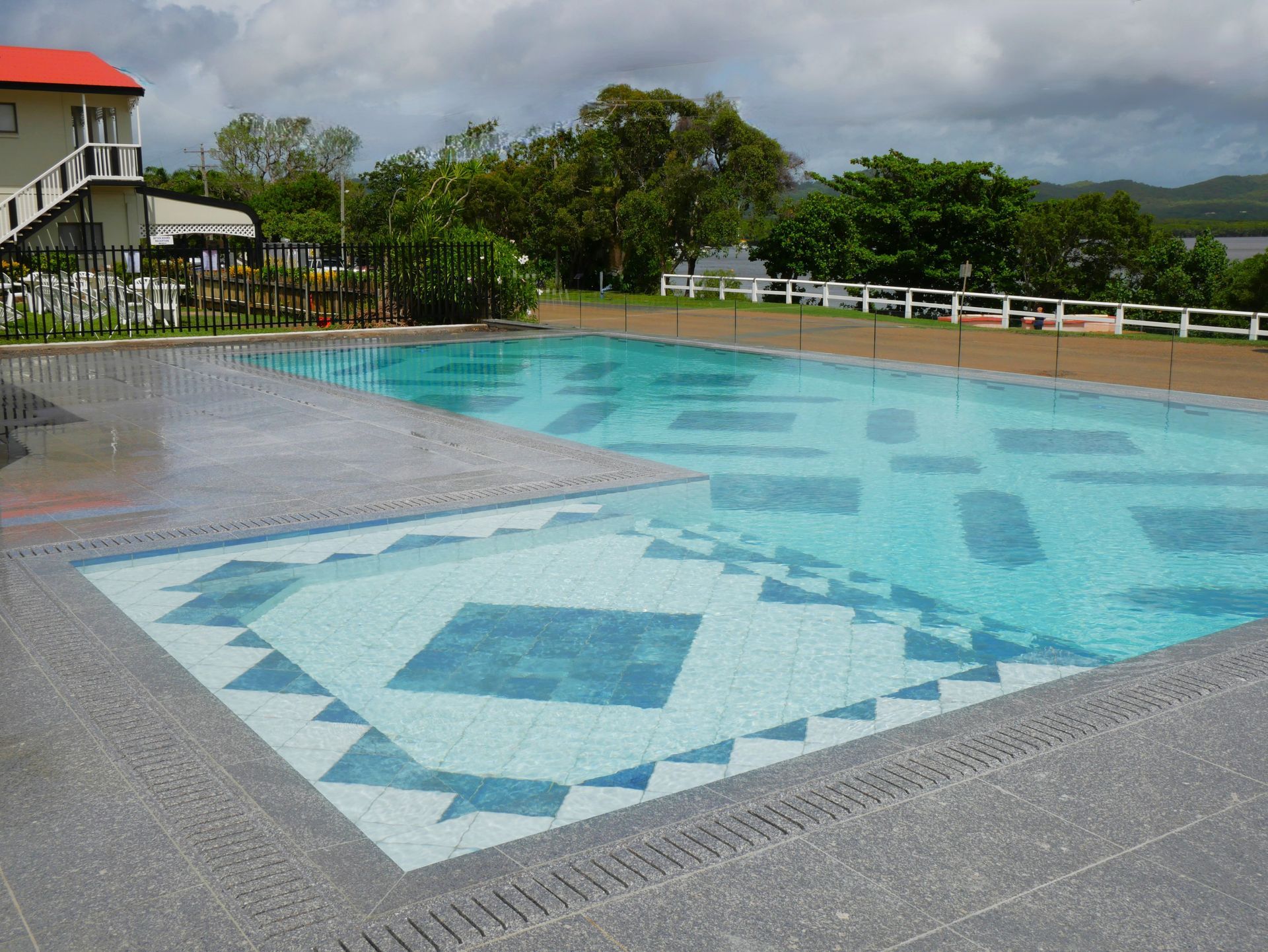 There Is a Large Swimming Pool in The Backyard of A House — Pools Plus NQ in Kewarra Beach, QLD