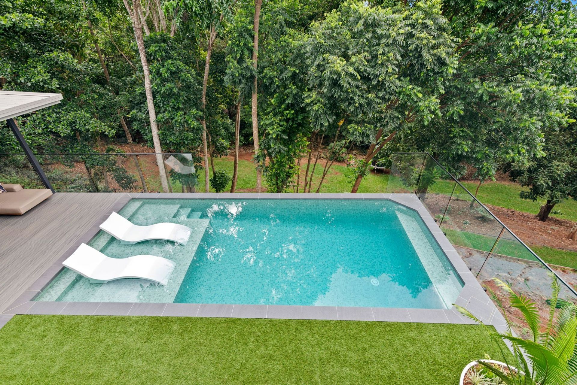 There Is a Large Swimming Pool in The Backyard of A House — Pools Plus NQ in Kewarra Beach, QLD