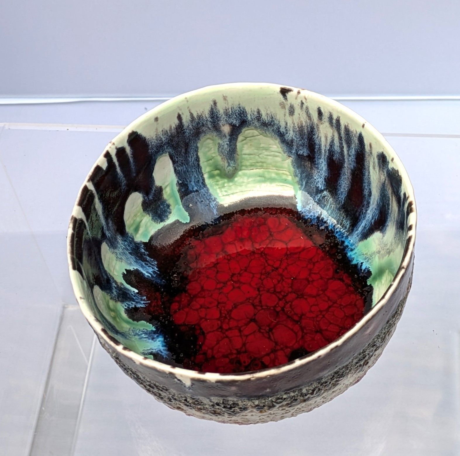 A colorful bowl with a red center sits on a table
