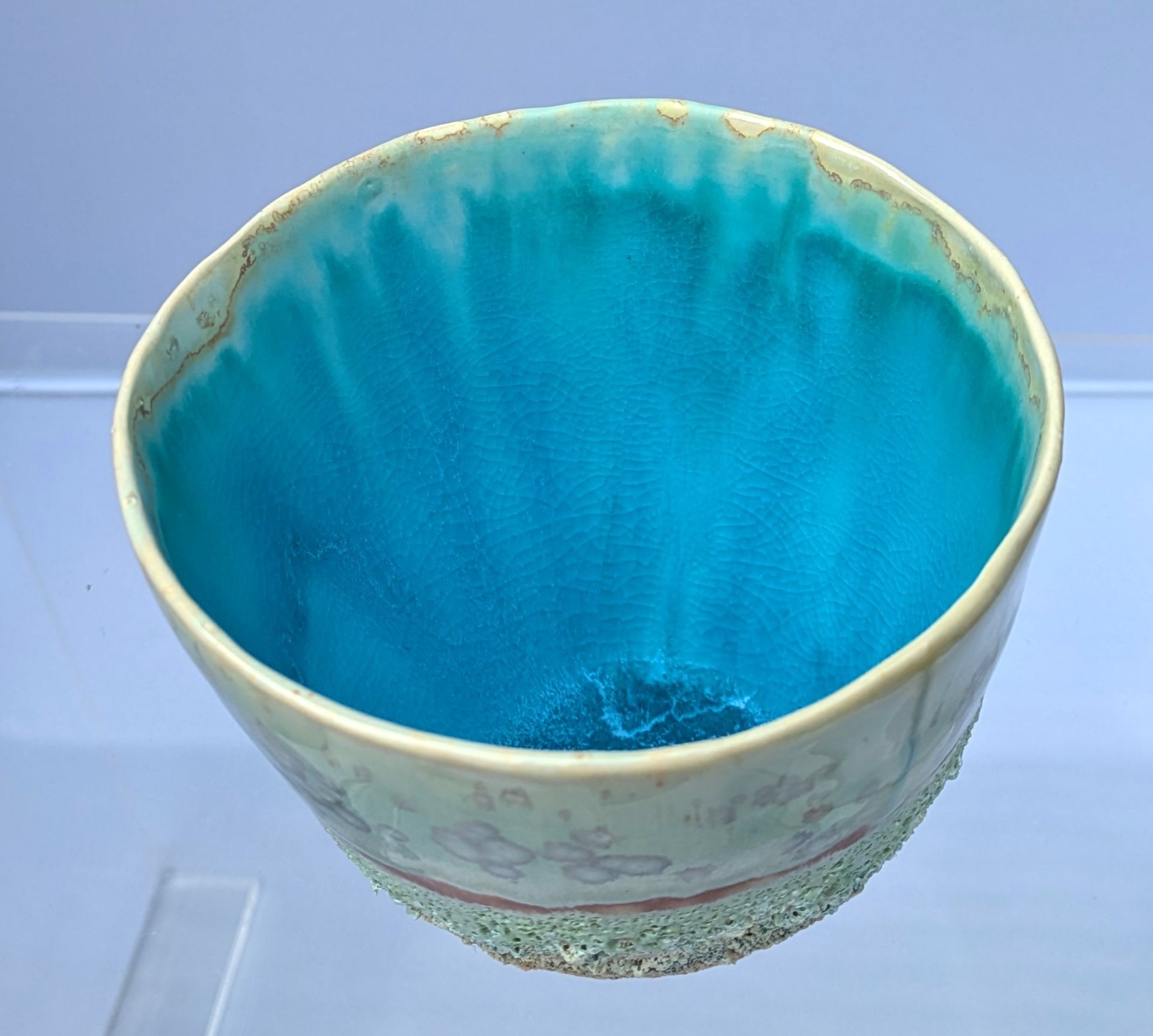 A blue bowl with a yellow rim sits on a table