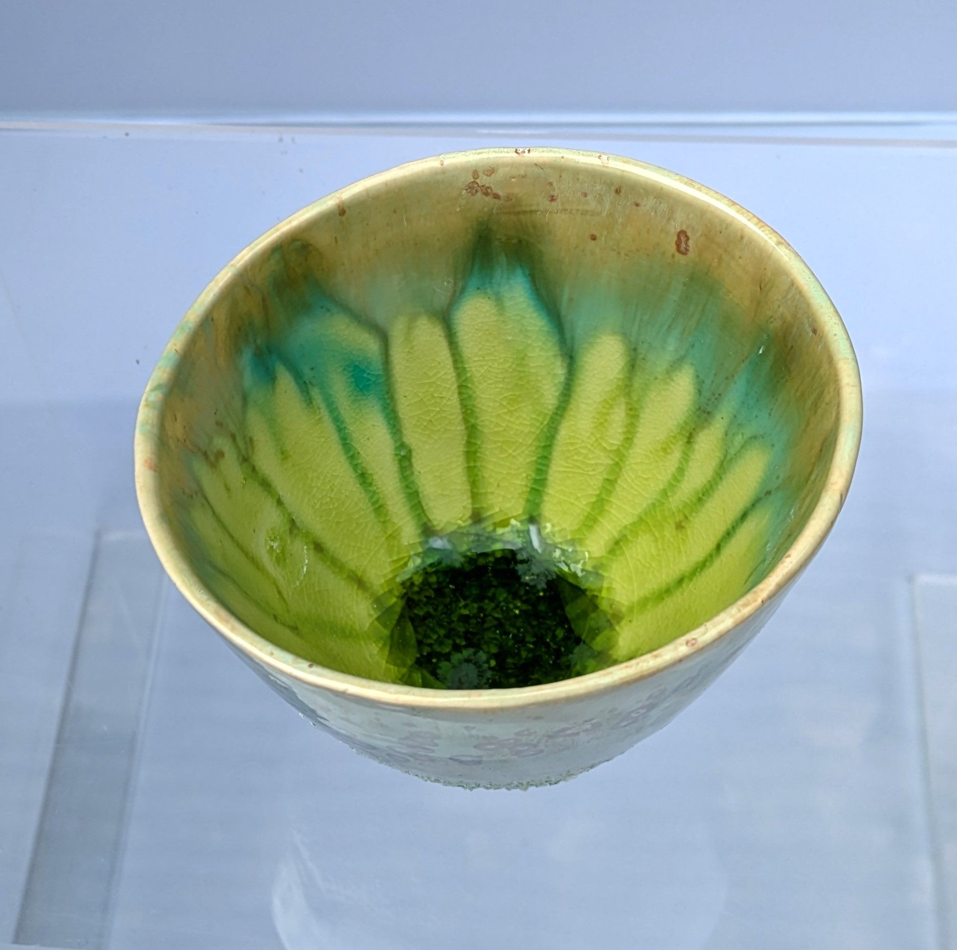 A green and gold bowl with a green center