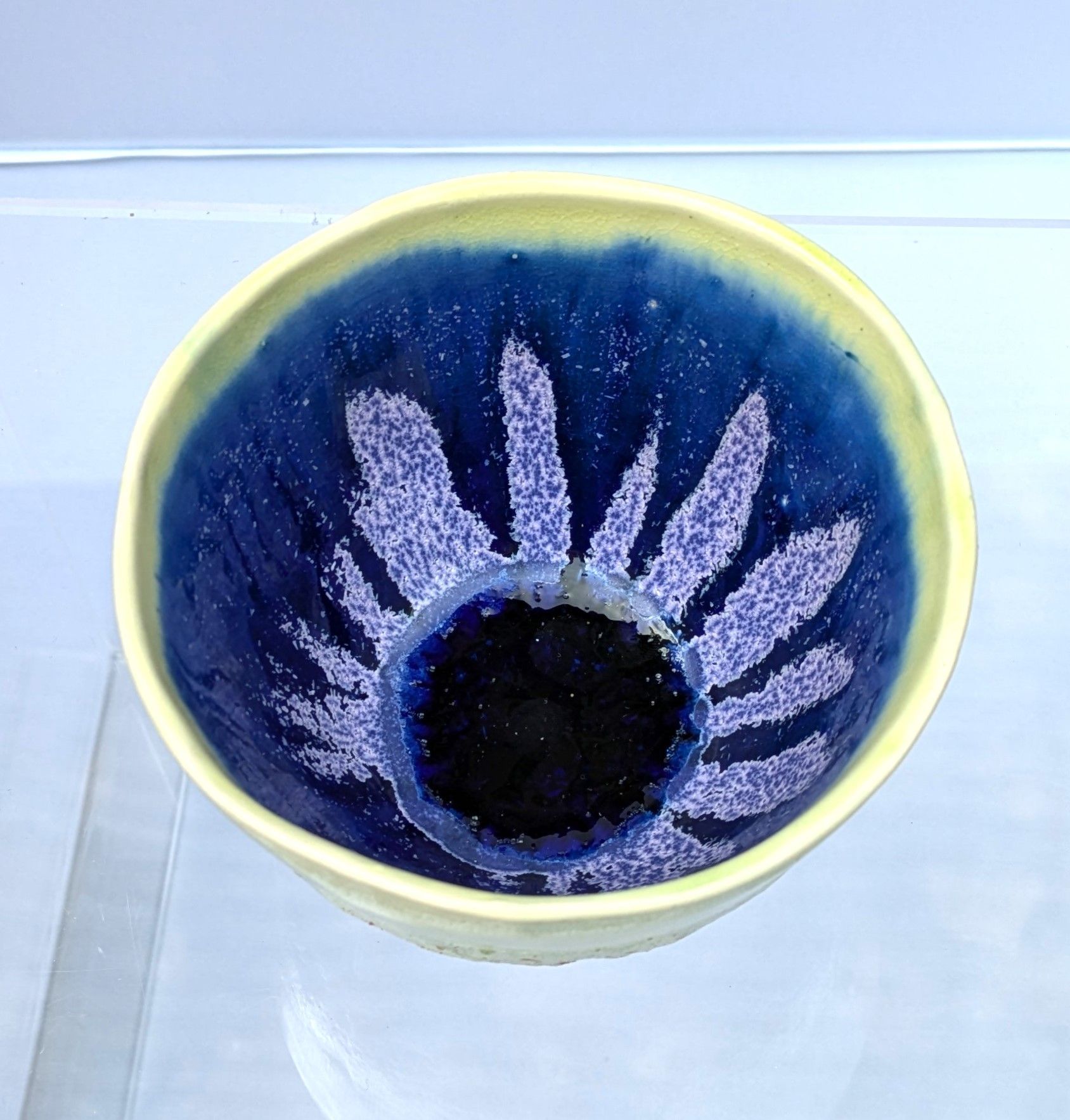 A blue and yellow bowl with a flower design on it