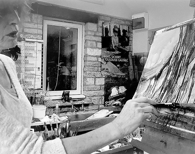 A black and white photo of Jill Jeffrey painting on an easel