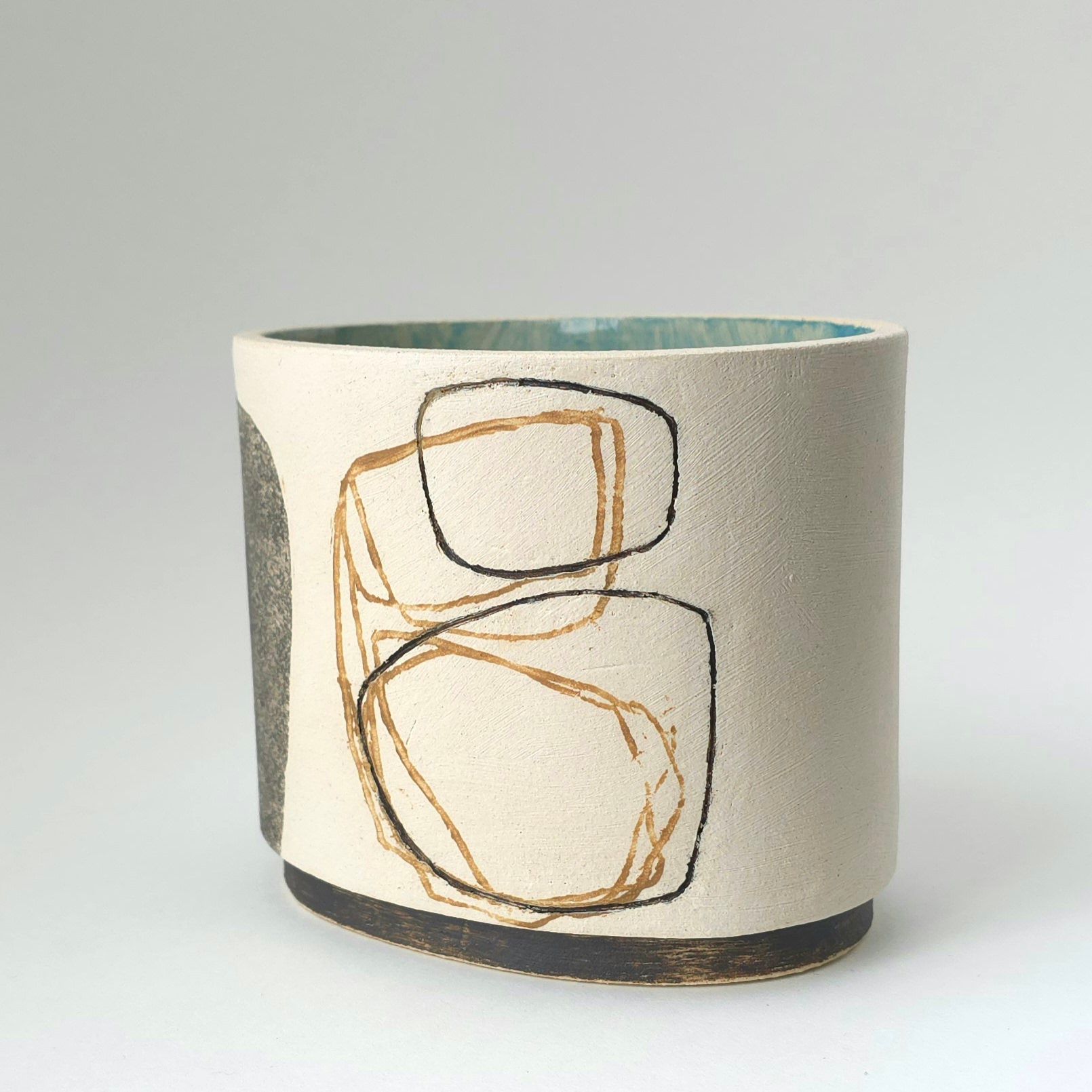 A white vase with a drawing of circles on it