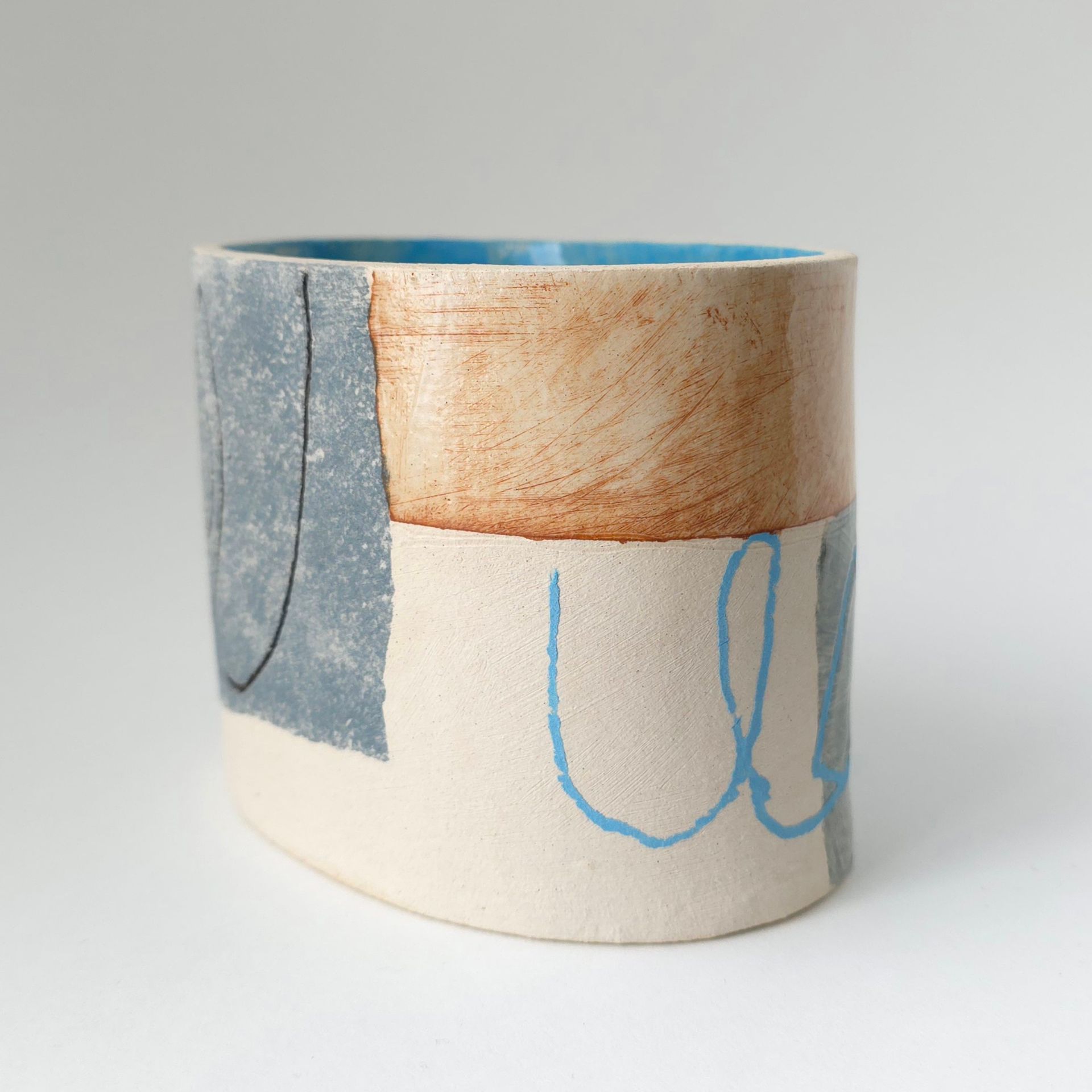 A ceramic vase with a blue and brown design on it