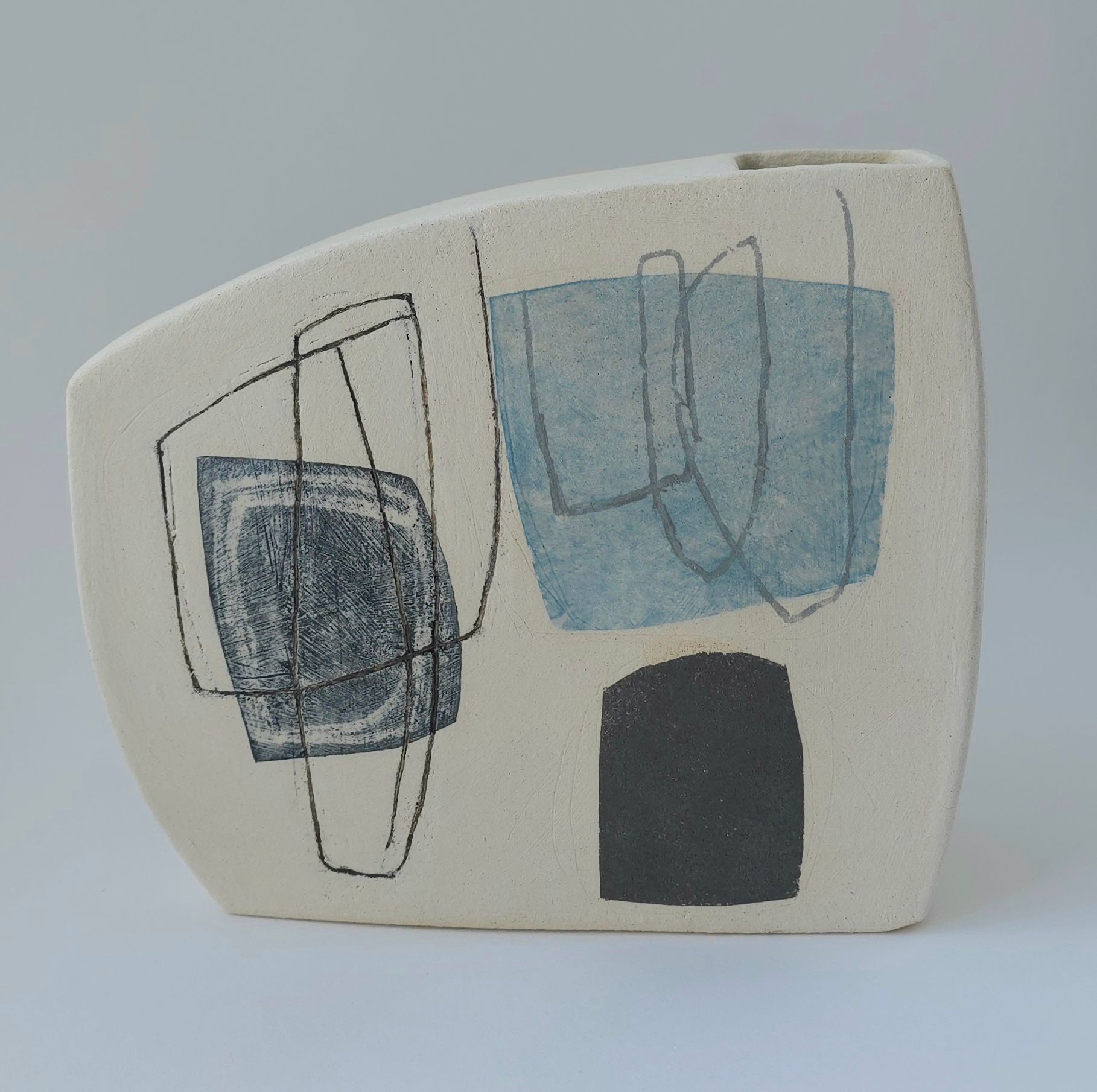 A white vase with a blue and black design on it
