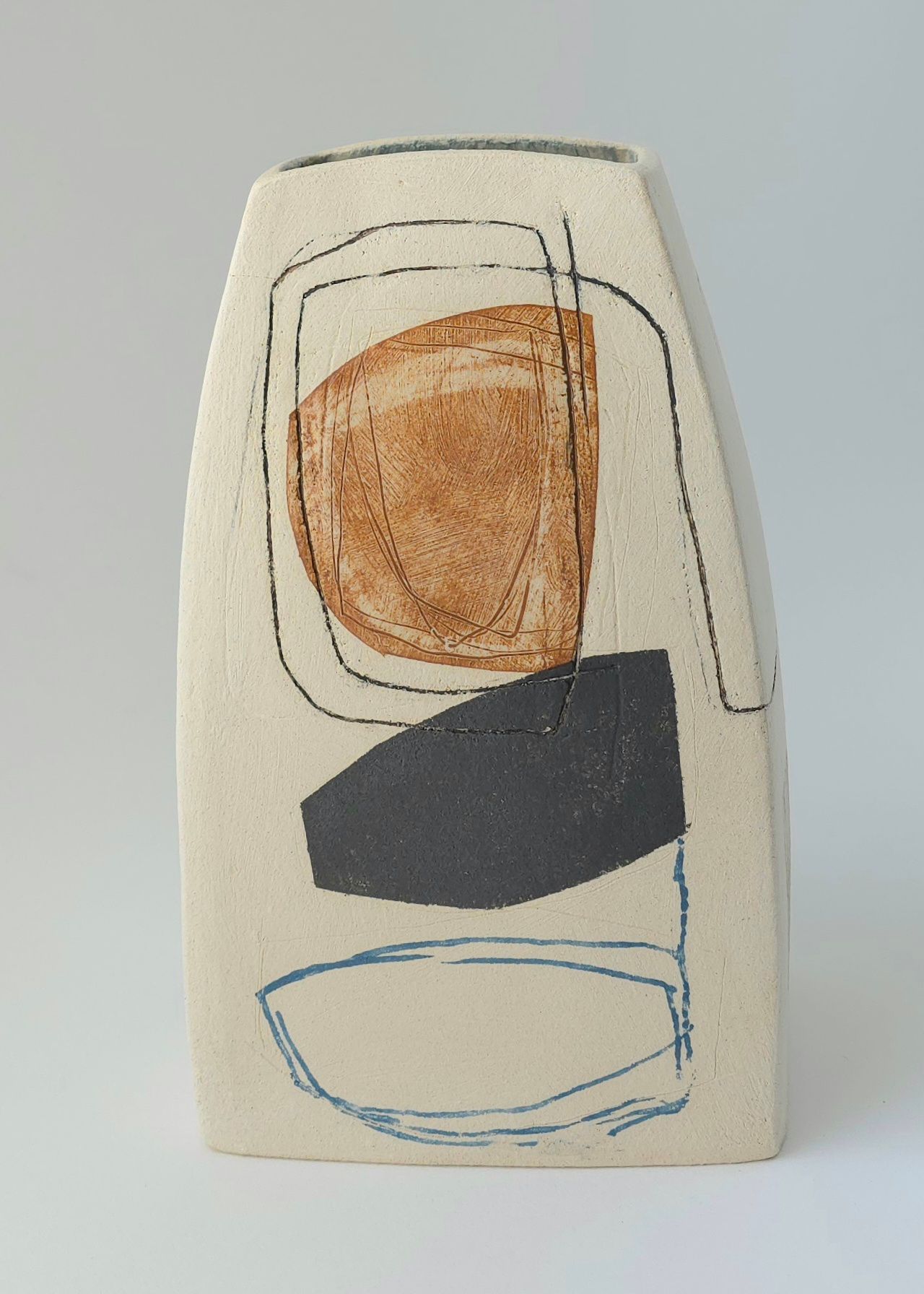 A ceramic vase with a drawing on it is sitting on a table.