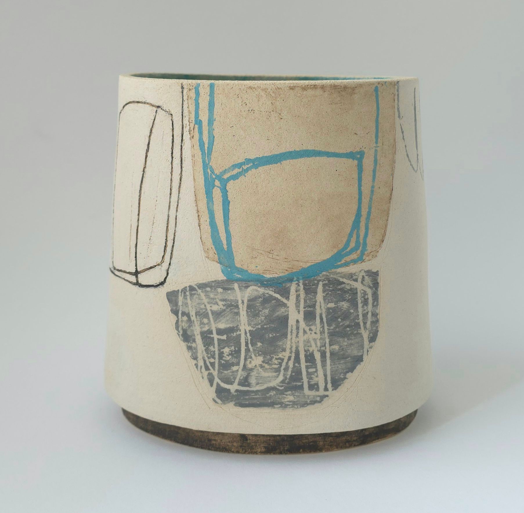 A white vase with a blue and gray design on it