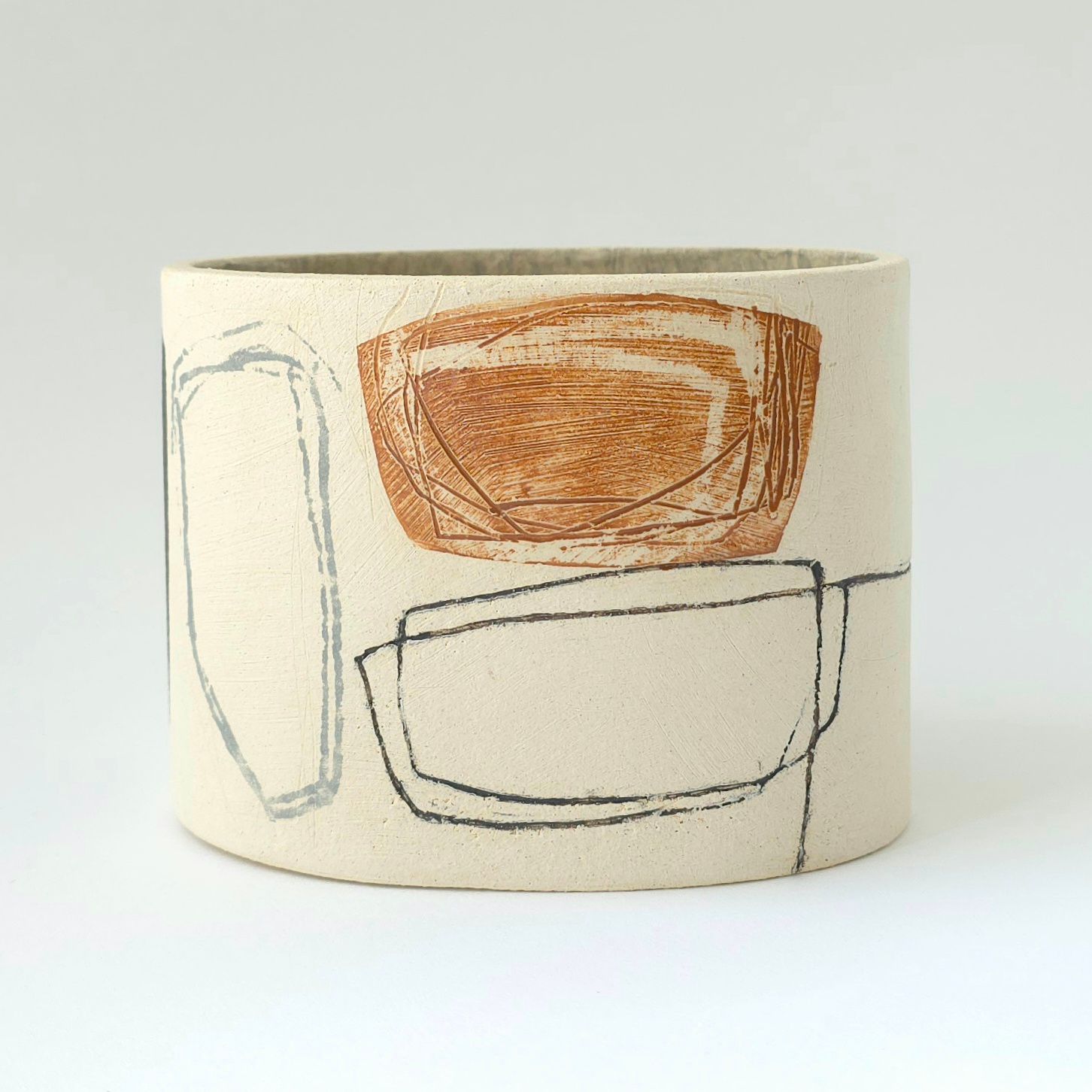 A vase with a drawing on it is sitting on a table.