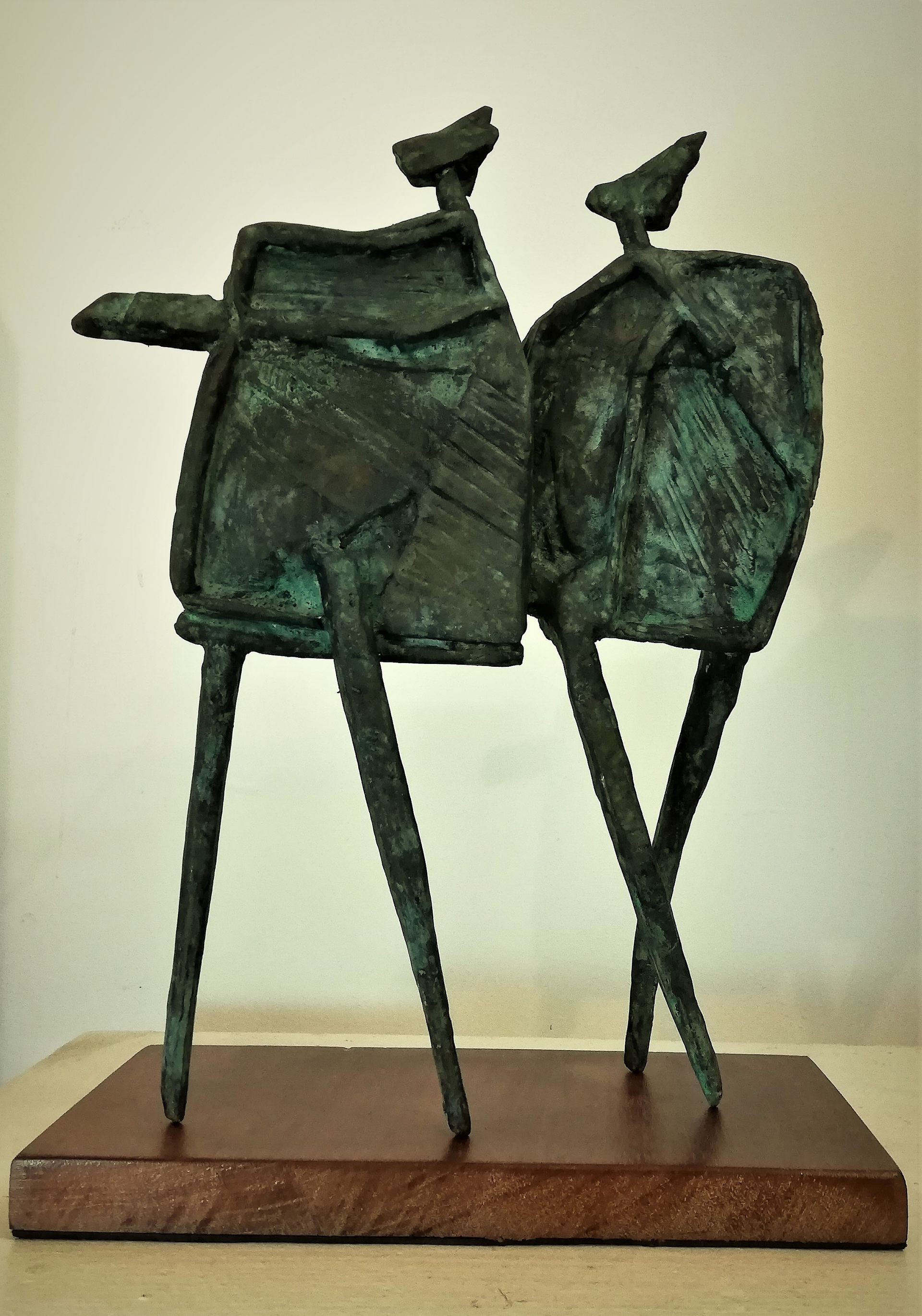 A statue of two people standing next to each other on a wooden base