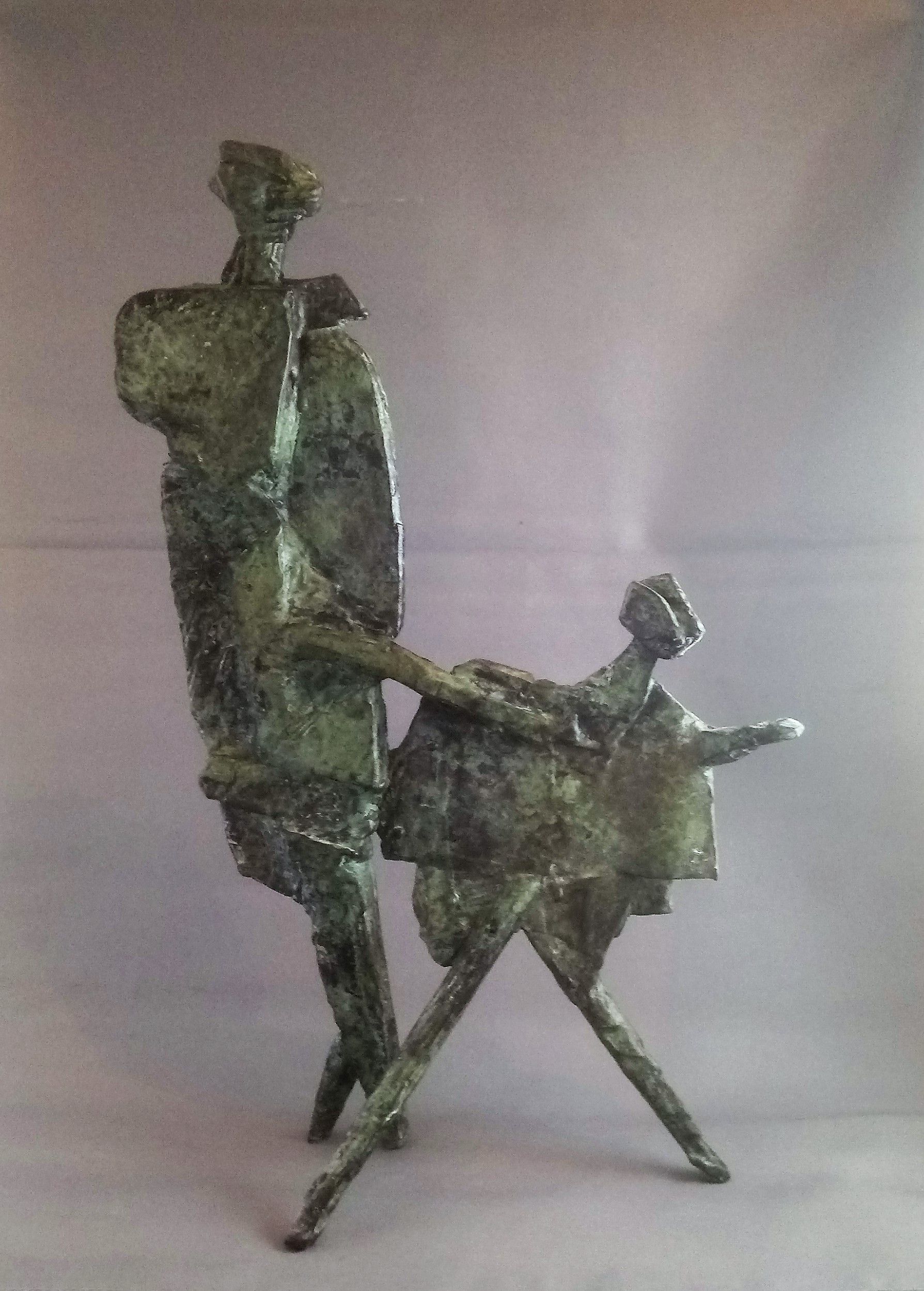 A statue of a man and woman standing next to each other on a table.