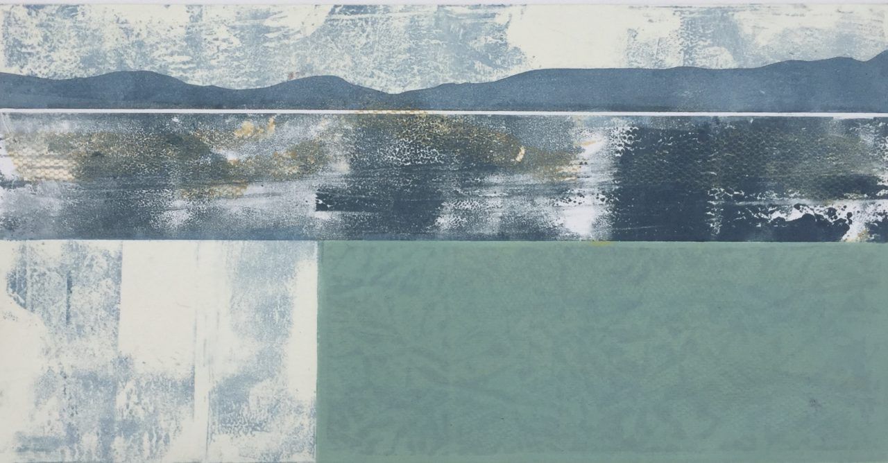 a close up of a monoprint of a lake with mountains in the background .