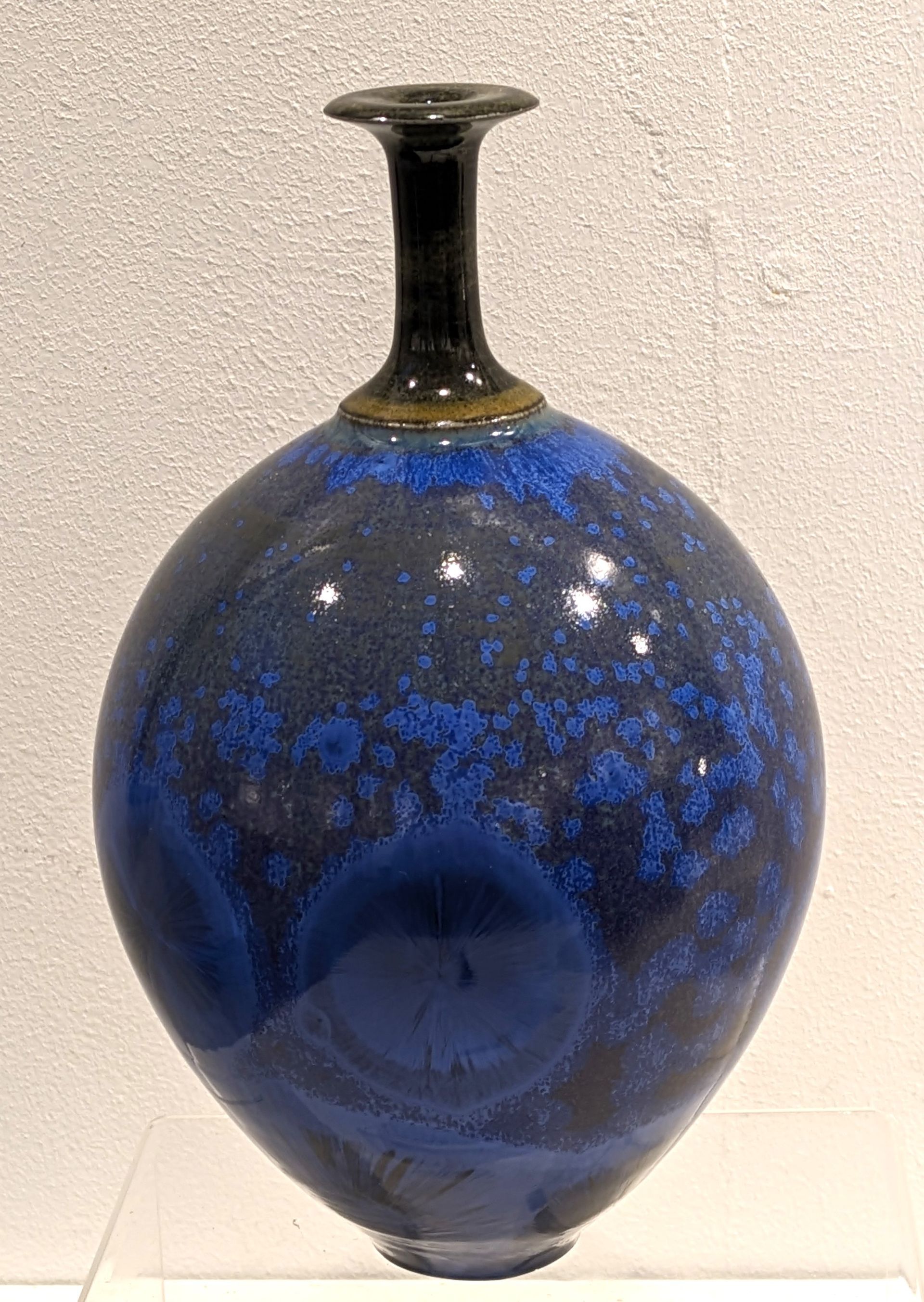 a blue vase is sitting on top of a white table .
