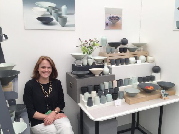 A woman sits in front of a table full of bowls
