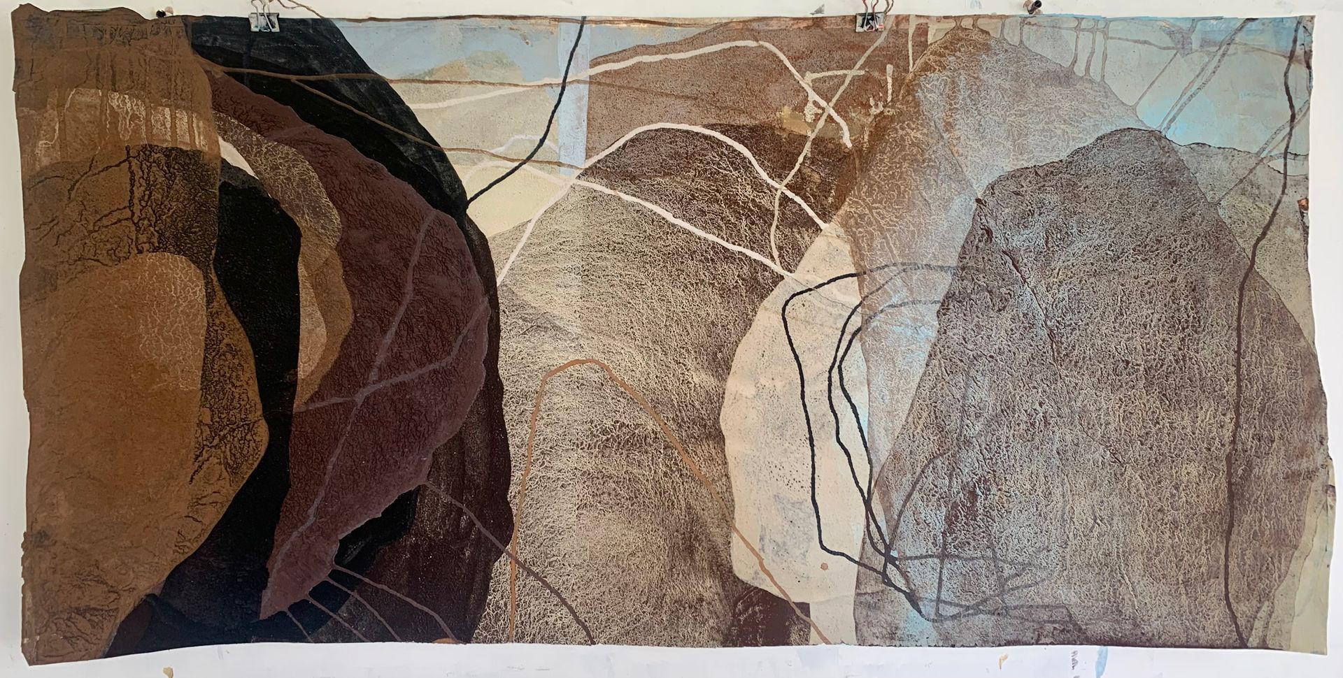 Abstract artwork with layered brown, beige, and gray organic shapes crossed by thin white lines