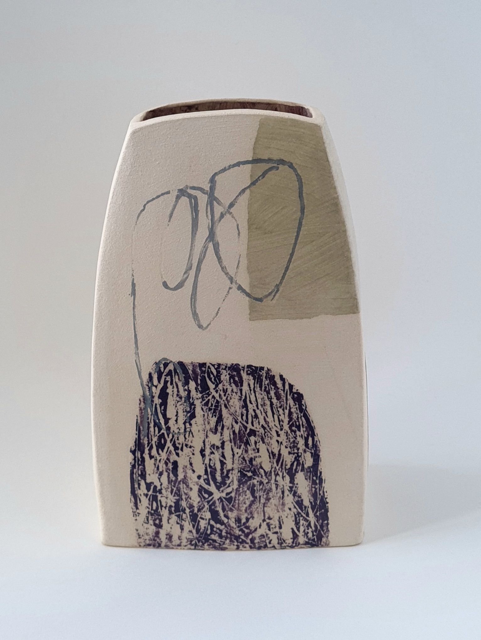 a white vase with abstract drawing on it