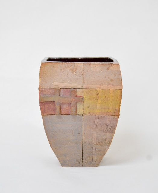 Tall beige ceramic vase with muted pink and yellow geometric panels on a white background