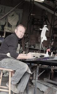 A man is sitting at a table with a spray bottle on it.