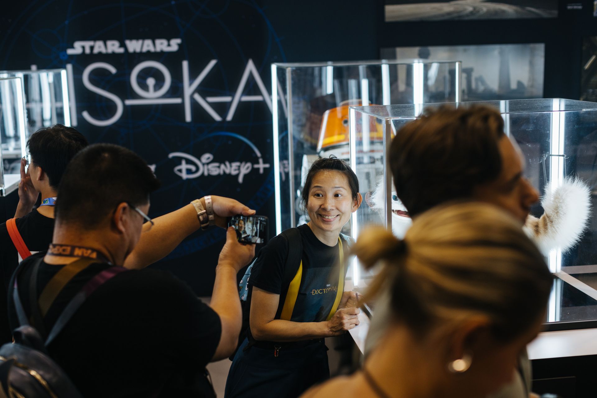 A group of people are standing in front of a star wars sign.