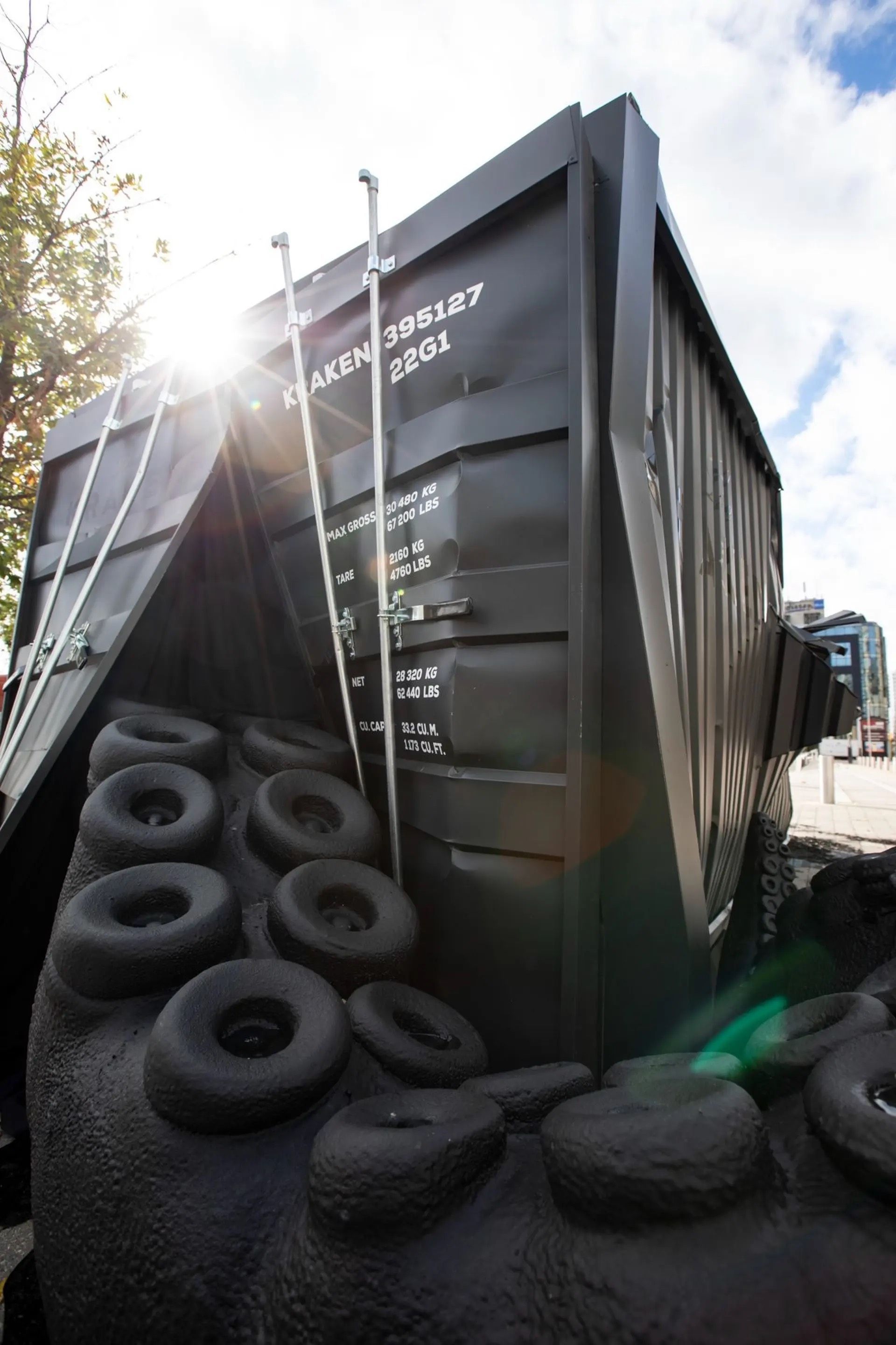 A large black container with a lot of tires on it
