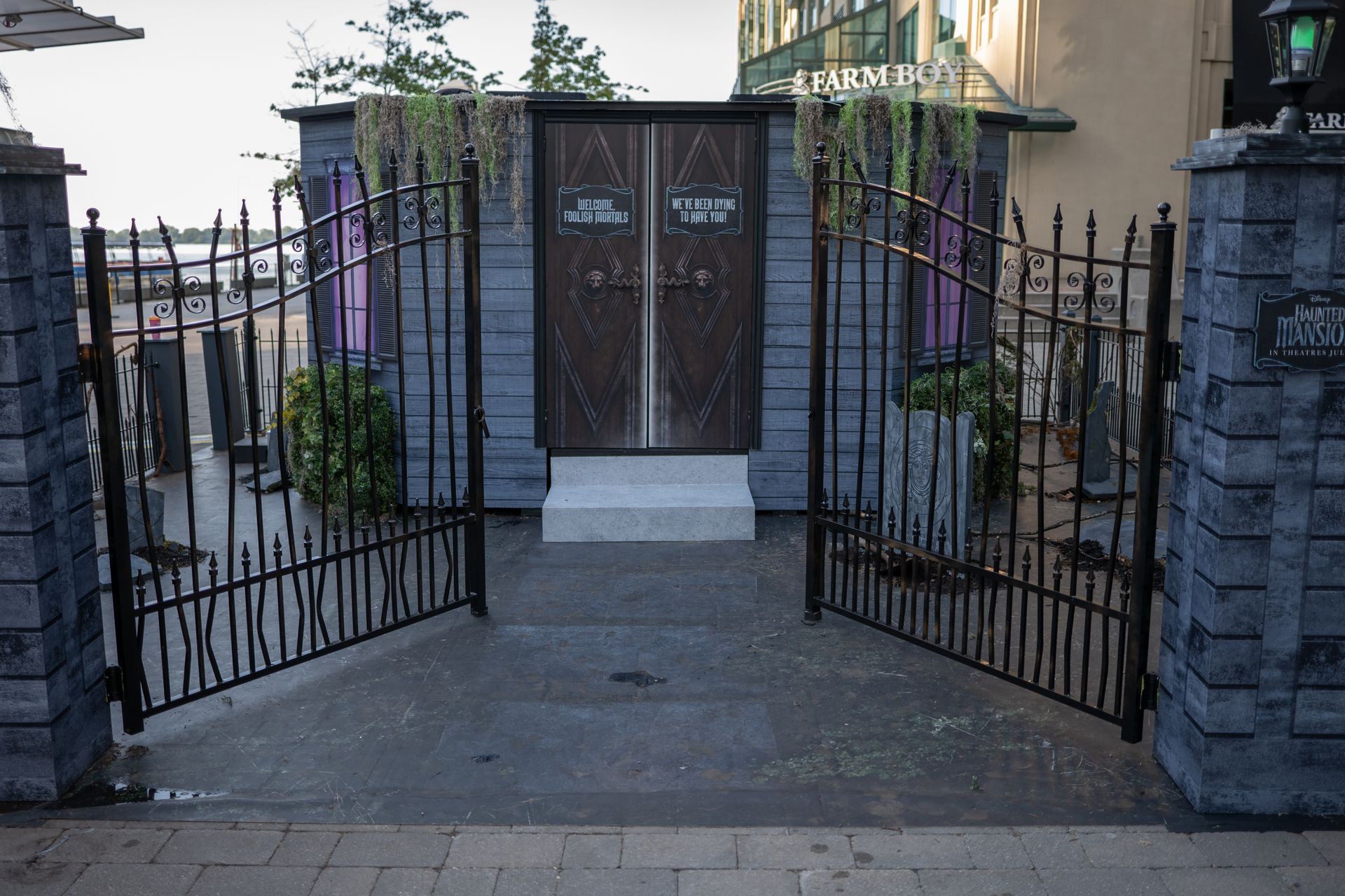 A wrought iron gate is open to a building