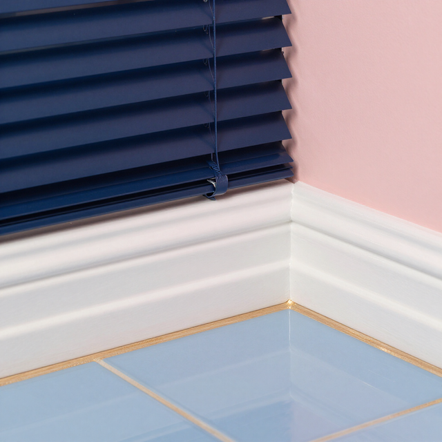 Corner of a room with navy blinds, pink walls, white trim, and glossy blue tile floor.
