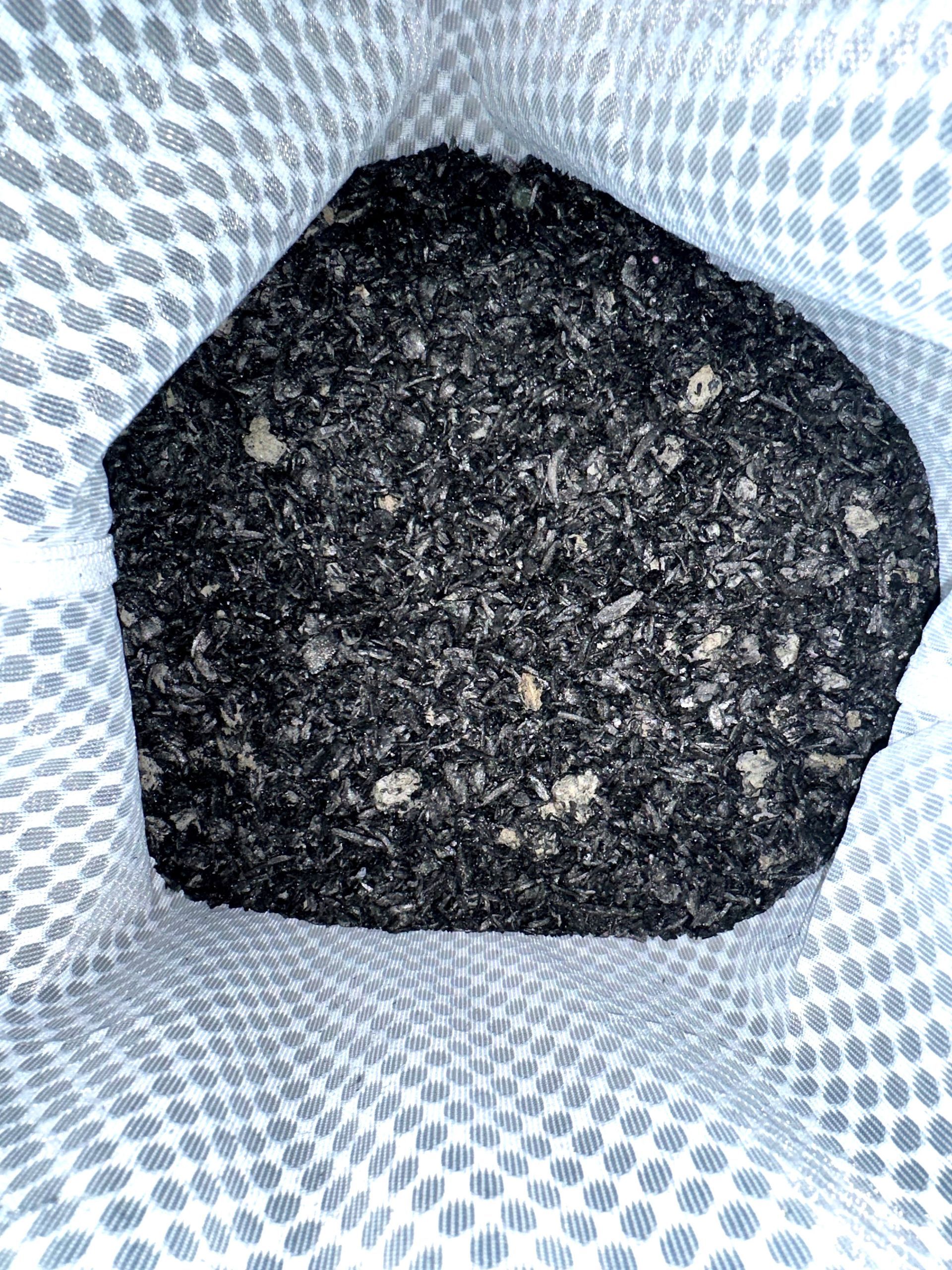 Pile of black granular material on a white background