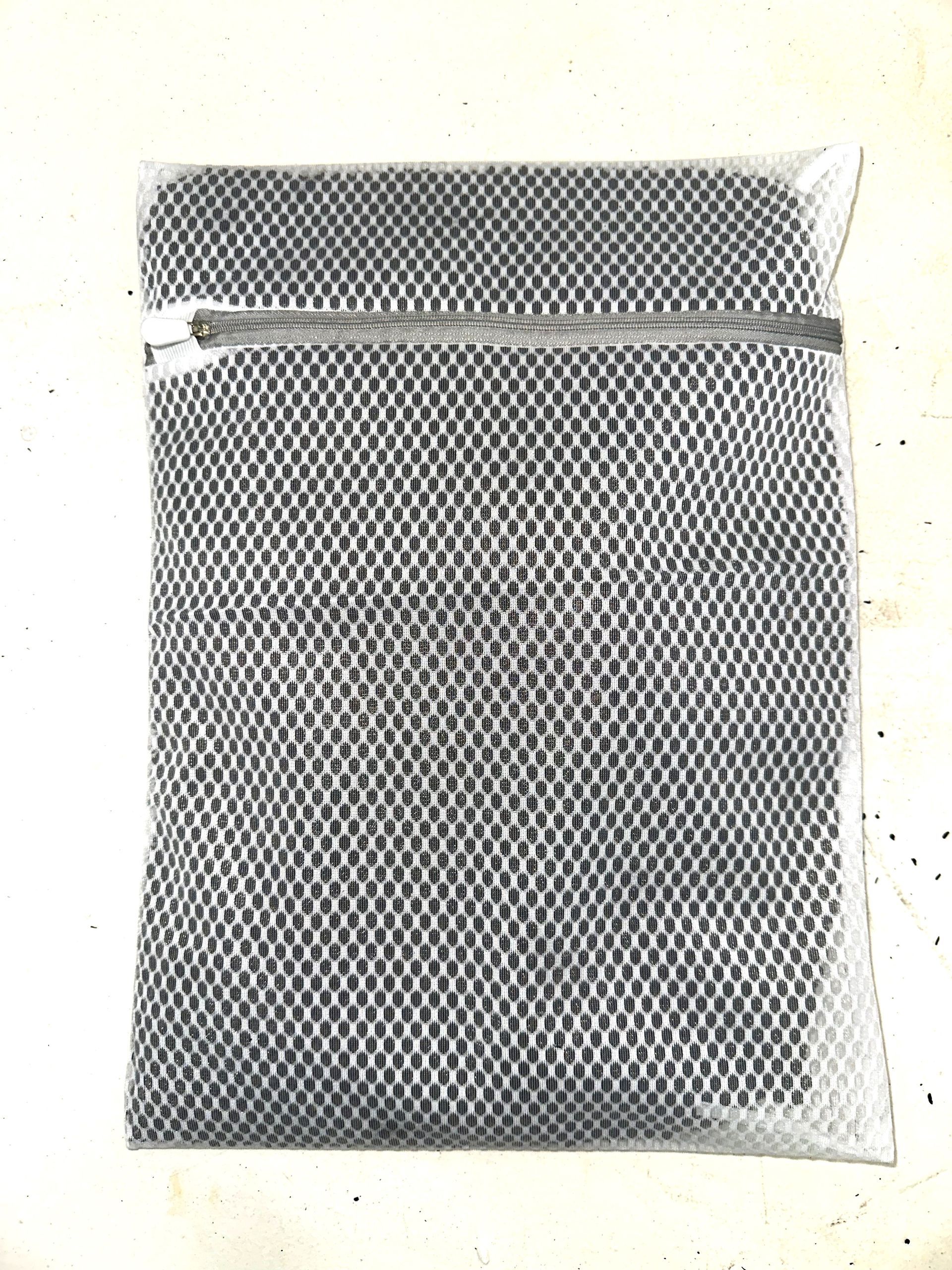 A black-and-white mesh pouch with a horizontal zipper near the top.
