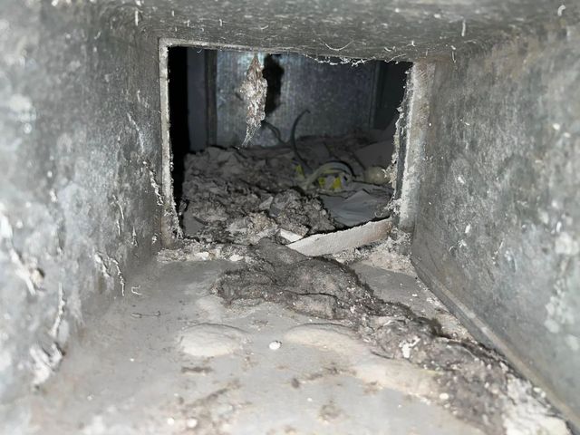 Damaged concrete tunnel with rubble and debris blocking the passage